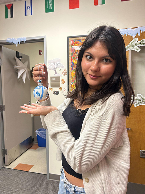 student holds painted ornament