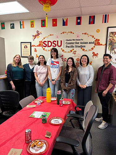 group of faculty and students pose at welcome event