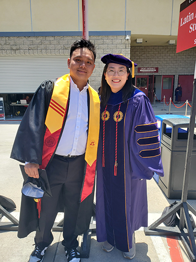 student with professor at commencmenet.